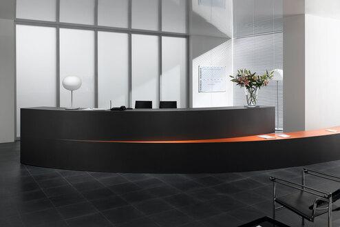 Hotelrezeption mit schwarzem Einrichtungsstil Hotelrezeption mit schwarz lackierter Empfangstheke und orangenem Kontrast