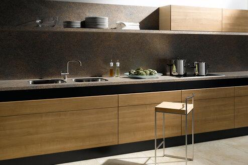 Küchenzeile aus Massivholz mit dunkler Arbeitsplatte Küchenzeile aus Massivholz mit schwarzer Arbeitsplatte, Spülbecken und Wandregal