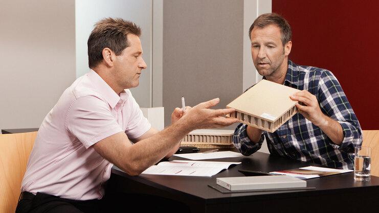 Beratung zu verschiedenen Holzmaterialien und -dichten Detailberatung zu verschiedenen Holzmaterialien -und dichten zwischen zwei Männern